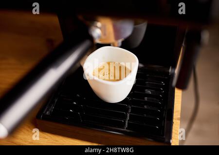 Preparazione di una tazza di caffè utilizzando una macchina espresso in un caffè, macchina da caffè preparazione di caffè espresso Foto Stock