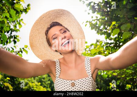 Foto di giovane gioiosa positiva affascinante donna tenere mani telecamera selfie buon umore sorriso all'aperto fuori casa parco Foto Stock