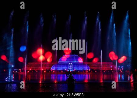 Una vista della 'Palm House Grand finale', che include proiezioni festive cadendo su un gigantesco schermo d'acqua nel lago durante il Natale a Kew presso i Royal Botanic Gardens di Kew, Londra. Data foto: Mercoledì 01 dicembre 2021. Il credito fotografico deve essere: John Walton/PA Wire Foto Stock