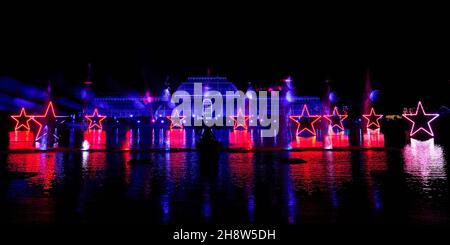 Una vista della 'Palm House Grand finale', che include proiezioni festive cadendo su un gigantesco schermo d'acqua nel lago durante il Natale a Kew presso i Royal Botanic Gardens di Kew, Londra. Data foto: Mercoledì 01 dicembre 2021. Il credito fotografico deve essere: John Walton/PA Wire Foto Stock