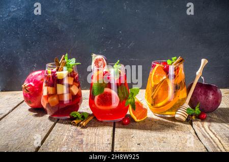 Tradizionale autunno inverno bere caldo piccante sangria - rosso, rosa, bianco. Con sidro, vino rosso rosa, mele, arance, melograno, mirtillo, prugna, fichi, Foto Stock