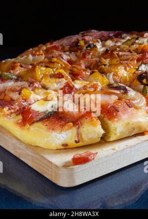 La pizza con salsiccia e formaggio su sfondo nero. Cottura sul tavolo. Prodotti dell'alimentazione Foto Stock