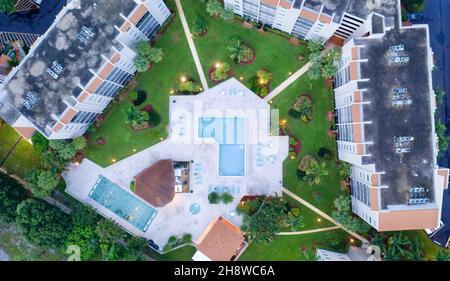 Scatto aereo direttamente sopra una piscina vuota in un complesso di appartamenti in la sera in Florida. Foto Stock