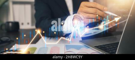 Il profitto del business finanziario e l'economia digitale in crescita, mano di uomo d'affari che tiene il tablet e controllare il grafico digitale e la tabella di criptovaluta Foto Stock