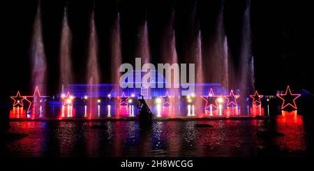 Una vista della 'Palm House Grand finale', che include proiezioni festive cadendo su un gigantesco schermo d'acqua nel lago durante il Natale a Kew presso i Royal Botanic Gardens di Kew, Londra. Data foto: Mercoledì 01 dicembre 2021. Il credito fotografico deve essere: John Walton/PA Wire Foto Stock