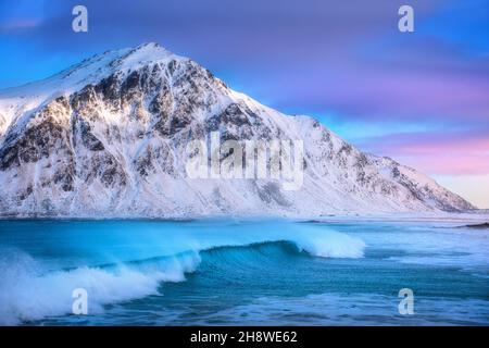 Spiaggia di sabbia con mare blu e onde in inverno al tramonto Foto Stock