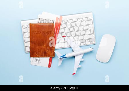 Concetto di viaggio e vacanza. Accessori e oggetti viaggio. Passaporto con biglietti, tastiera e giocattolo dell'aeroplano. Vista dall'alto, disposizione piatta Foto Stock