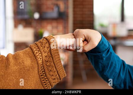 Primo piano dei colleghi che salutano dando il primo urto durante la pandemia del covid19 mentre lavorano nell'ufficio di startup. Businessteam pianificazione gestione presentazione brainstorming idee. Concetto aziendale Foto Stock