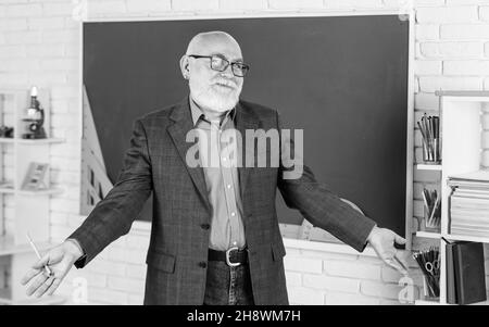 Insegnante di uomo intelligente senior alla lavagna. Insegnante di vecchia generazione di scuola. Docente esperto. Insegnante maturo godere di insegnamento. Condivisione delle conoscenze Foto Stock