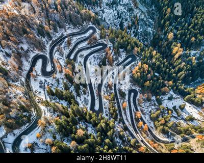 Vista aerea da drone sulla strada di passaggio più spettacolare delle Alpi svizzere - Passo Maloja nei primi mesi invernali e autunnali, Grison, Svizzera Foto Stock