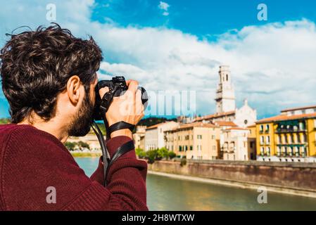 Un giovane fotografo dilettante in visita turistica in Italia scatta una fotografia ricordo Foto Stock