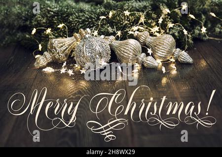 Allegro ornamenti di Natale in baubles con luci dorate. Immagine dai toni vintage Foto Stock