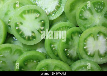 uno sfondo con pomodori verdi Foto Stock