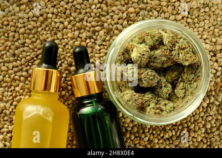 Prodotti cosmetici marijuana, olio CBD. Estratto di canapa medicinale in bottiglie cosmetiche su fondo di semi di cannabis. Cura naturale delle erbe, uso medico, orlo Foto Stock