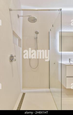 Interno di ampio bagno luminoso con nuovi mobili in stile minimalista in moderno appartamento di lusso Foto Stock