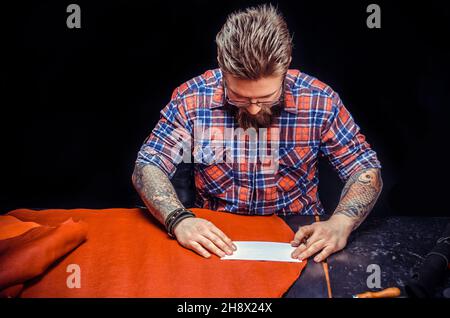 Uomo al lavoro con cuoio fabbricazione di nuovi prodotti in pelle Foto Stock