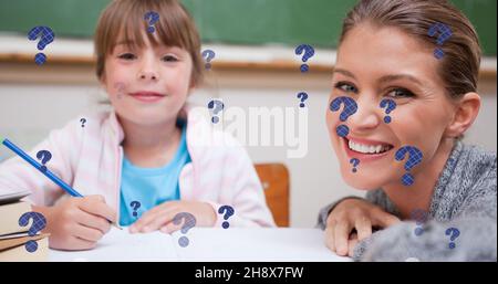 Composizione digitale di punti interrogativi su una scolarista sorridente e un insegnante alla scrivania in classe Foto Stock