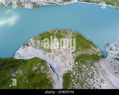 Sedimenti di sorgente di montagna che entrano nel lago, che forma un ventilatore o foglia di gingko forma - una vista aerea dal drone Foto Stock