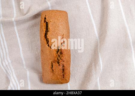 Pane casereccio di pasta di segale affettato su un tagliere su tavola bianca, immagine ravvicinata, messa a fuoco selettiva Foto Stock