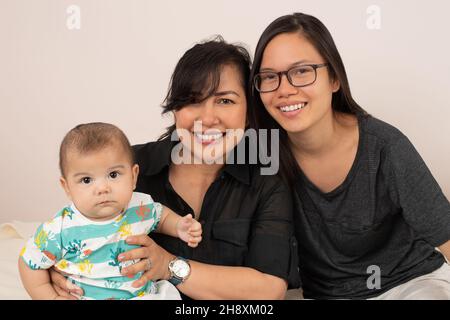 bambino di 3 mesi con sorella maggiore, di 20 anni e madre, ritratto, guardando la macchina fotografica Foto Stock