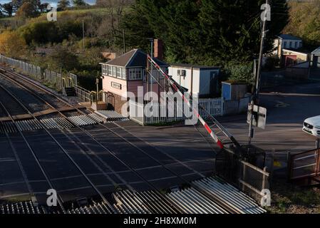 Crediton, Devon, Inghilterra. 2021. Panoramica della chiusura della barriera di attraversamento a livello, traffico a Crediton lungo la linea ferroviaria per Okehampton e Barnstable. Foto Stock