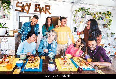 Amici che si divertono a colazione a buffet - gente multiculturale alla moda che mangia il brunch mattutino allo Sky bar caffetteria - concetto di stile vita Foto Stock