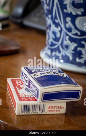 Due pacchetti di carte da gioco su un tavolo con un vaso blu e bianco Foto Stock