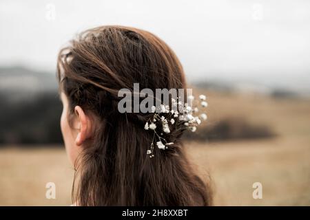 Primo piano sui fiori nei capelli della sposa Foto Stock