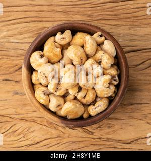 Canjica, popcorn hominy o bianco, popcorn dolce in una ciotola sopra tavola di legno. Foto Stock