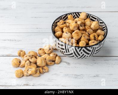 Canjica, popcorn hominy o bianco, popcorn dolce in una ciotola sopra tavola di legno. Foto Stock