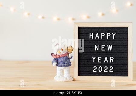 Felice anno nuovo 2022 saluti sul bordo della lettera sul tavolo con le decorazioni di festa e spazio di copia Foto Stock