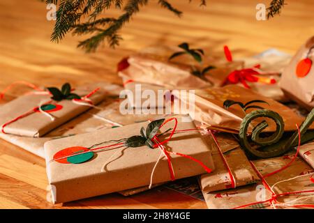 Regali di Natale Composition.Xmas con i nastri verdi rossi ed il decor.presenta del ramo dell'albero avvolto in carta riciclata artigianale e in vacanza di arco.Inverno della corda Foto Stock