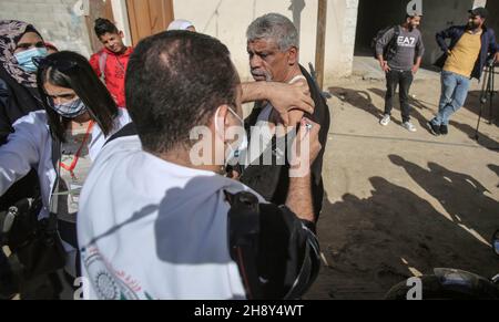 Gaza, Palestina. 2 dicembre 2021. Un medico vaccina un uomo palestinese nel villaggio beduino nella zona meridionale di Gaza, durante la campagna. L'UNICEF, Save Youth Future e il Ministero palestinese della Sanità hanno lanciato una campagna di sensibilizzazione sull'importanza della vaccinazione contro il Coronavirus per il popolo palestinese, soprattutto dopo la nuova variante 'Omicron' nel villaggio beduino a sud di Gaza City. Credit: SOPA Images Limited/Alamy Live News Foto Stock