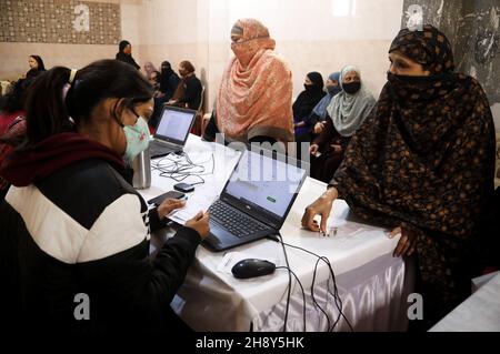 New Delhi, India. 2 dicembre 2021. Le donne musulmane si registrano prima di ricevere una dose di vaccino Covid-19 durante il campo di vaccinazione COVID-19 a Sakur ki Danadi (SKD) Basti a Old Delhi.Health Ministero ufficiale ha detto che due casi della nuova variante di virus corona Omicron sono stati rilevati da Karnataka nel paese. L'India ha segnalato 9,765 infezioni fresche del virus della corona nelle ultime 24 ore. Credit: SOPA Images Limited/Alamy Live News Foto Stock