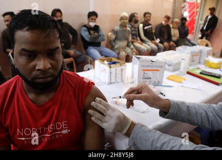 New Delhi, India. 2 dicembre 2021. Un operatore sanitario somministra una dose di vaccino covid-19 ad un uomo durante il campo di vaccinazione covid-19 a Sakur ki Danadi (SKD) Basti a Old Delhi.Health Ministero ufficiale ha detto che due casi della nuova variante del virus corona Omicron sono stati rilevati da Karnataka nel paese. L'India ha segnalato 9,765 infezioni fresche del virus della corona nelle ultime 24 ore. Credit: SOPA Images Limited/Alamy Live News Foto Stock