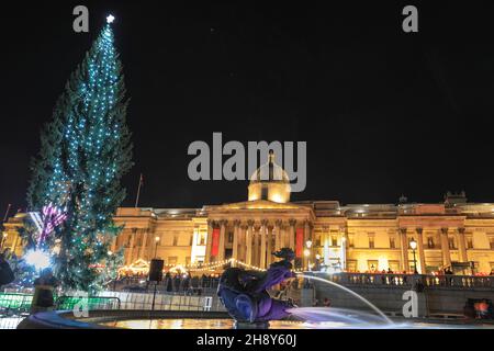 Westminster, Londra, 2 dicembre 2021. L'albero illuminato si erge alto, accanto a Trafalgar Square Menorah, fontane e Galleria Nazionale sullo sfondo. Le luci dell'albero di Natale di Trafalgar Square si accendono questa sera in una cerimonia tradizionale. L'albero alto 25 metri, di solito un abete norvegese, è un regalo dalla gente di Norvegia a Londra, grazie per il sostegno della Gran Bretagna nella seconda guerra mondiale Questa tradizione storica è avvenuta ogni anno dal 1947. Credit: Imagplotter/Alamy Live News Foto Stock