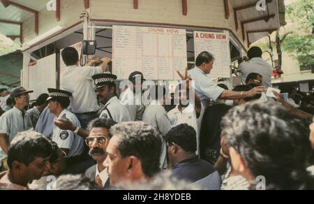 Giocatori al giorno di corse a Port Louis: Spingere e sparare in un negozio di scommesse dietro la tribuna del Mauritius Turf Club MTC Foto Stock