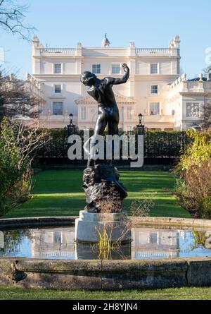 Vista di St John's Lodge, Regent's Park, Londra UK, fotografata in una giornata invernale limpida dal giardino di rose. Statua di Hylas in primo piano. Foto Stock