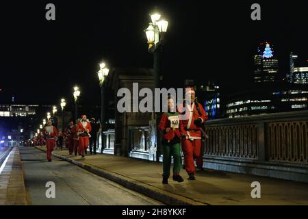 Londra, Regno Unito, 2 dicembre 2021, centinaia di escursionisti, Gli utenti in sedia a rotelle e i corridori hanno partecipato all'evento festivo 'Santa in the City' 5K. I partecipanti che hanno donato Santa Suits e Beards hanno seguito un percorso intorno alla Southbank e alla City di Londra - alcuni erano in squadre in esecuzione per il Maggies Centre, la Royal Marsden Cancer Charity, Single Homeless Project e molte altre cause. Credit: Undicesima ora Fotografia/Alamy Live News Foto Stock