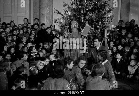 Warszawa, 1946-12. Choinka dla najbiedniejszych dzieci zorganizowana przez premiera Edwarda Osóbkê-Morawskiego w sali Kolumnowej Pa³acu Namiestnikowskiego, siedzibie Rady Ministrów przy Krakowskim Przedmieœciu. Dzieci otrzyma³y paczki z prezentami. Z mikrofonem sprawozdawca radiowy redaktor Tadeusz Pyszkowski. rd PAP/Jerzy Baranowski Dok³adny dzieñ wydarzenia nieustalony. Warszaw, 1946 dicembre. Festa di Natale per i bambini più poveri organizzata dal primo Ministro Edward Osobka-Morawski alla Sala Kolumnowa del Palazzo Namiestnikowski, sede del Consiglio dei Ministri su Krakowskie Pr Foto Stock