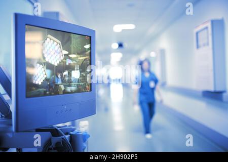 Traduzione dell'operazione sul monitor nel corridoio ospedaliero, concetto di tecnologie moderne nel settore sanitario. Foto Stock