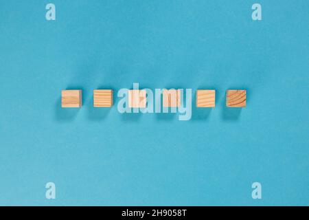 6 cubi di legno allineati senza scrivere per personalizzare su sfondo azzurro Foto Stock