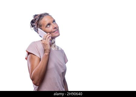 Una donna adulta che parla con il telefono mentre guarda in su Foto Stock