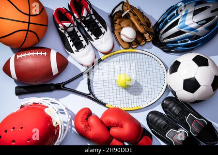 Vista ad angolo alto di varie attrezzature sportive su sfondo blu Foto Stock