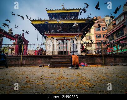 Kathmandu, Bagmati, Nepal. 3 dicembre 2021. Un devotee indù nepalese offre grani che camminano intorno al tempio di Shiva in ricordo di quelli defunti durante il festival di Bala Chaturdashi a Kathmandu, Nepal il 3 dicembre 2021. Il festival Bala Chaturdashi è segnato in onore dei membri defunti della famiglia dove i devoti spargono sette diversi tipi di semi. I devoti passavano un'intera notte sveglio e illuminavano le lampade ad olio in nome della memoria del defunto, prima di un giorno. (Credit Image: © Sunil Sharma/ZUMA Press Wire) Foto Stock