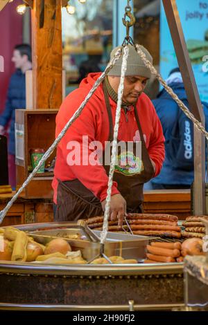 il mercato tedesco della salsiccia si trova in un mercato di natale, mentre i hot dog e le salsicce sono cucinati in un mercato di natale nella città di southampton; Foto Stock
