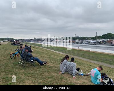 Autodromo di Santa Pod Bedfordshire UK, auto da corsa per prati seduto a guardare le auto calde in asfalto mentre guardano le persone che si esibiscono in sport vincendo in attesa Foto Stock