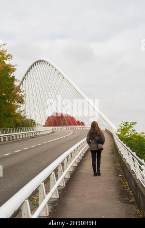 Le donne camminano sul ponte. Autunno natura. Architettura moderna. Ponte di sospensione Foto Stock