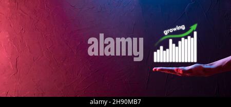 Uomo d'affari che tiene i grafici olografici e le statistiche di borsa guadagnano i profitti. Concetto di pianificazione della crescita e strategia aziendale. Visualizzazione di ec in buono stato Foto Stock