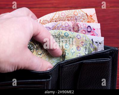 Qatari Money - Riyal nel portafoglio nero Foto Stock